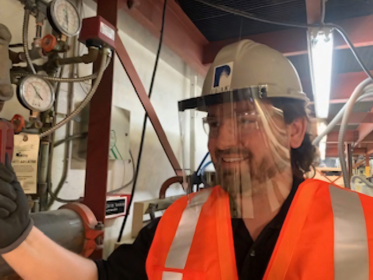 Protoplast employee wearing a company-made face shield and hard hat